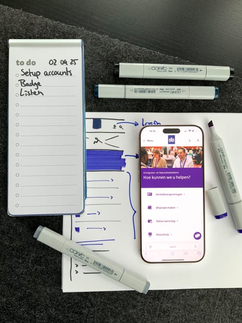 Top-down view of a desk with markers, a wireframe of the Dutch Immigrations Office's website and a To Do list
